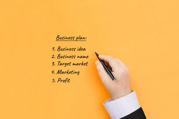 The concept of creating a business plan. Businessman writes down a business development strategy plan.