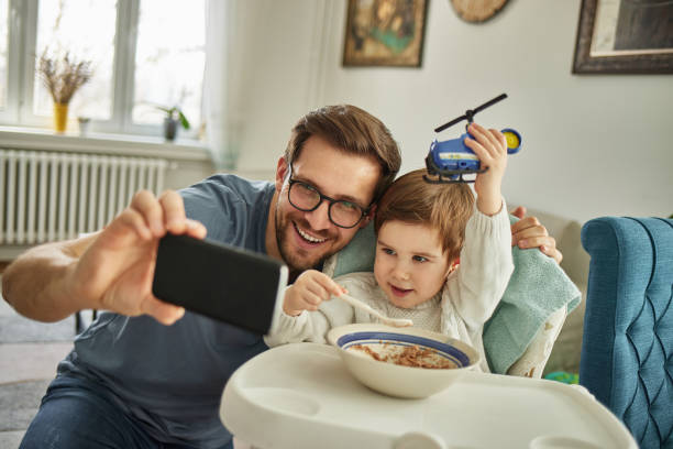 istock A single father and baby son taking selfie at home 1361467472