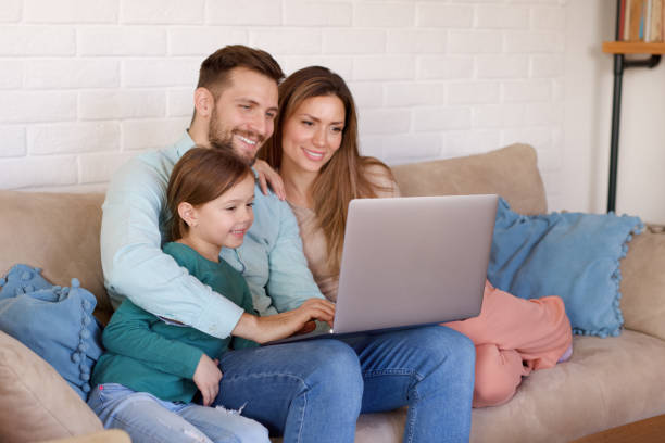 istock Smiling family relaxing at home and using laptop together 1361468111