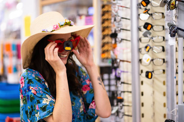 istock Woman laughing while trying on sunglasses in a store 1361469414