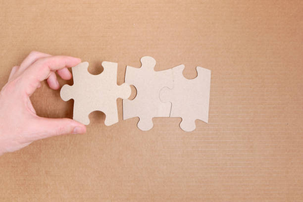istock Man's hand attaches the missing piece of the puzzle. 1361469584
