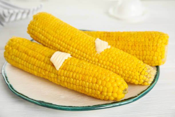 istock Fresh corn cobs with butter on white wooden table 1361470686