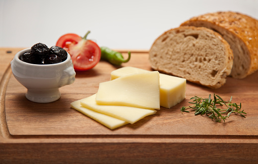 cheese,bread,tomato and olive on the cutting board