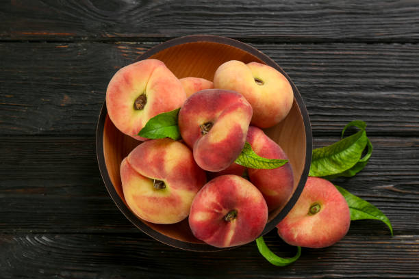 istock Fresh ripe donut peaches on black wooden table, flat lay 1361472798