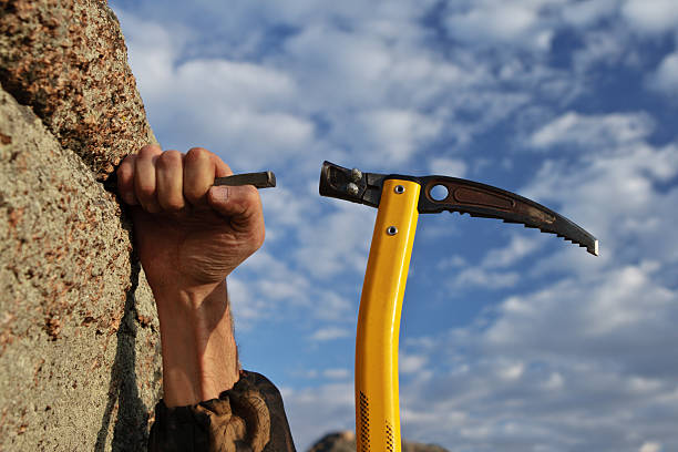 istock Hands rock-climber hammering in hook rock 136147296