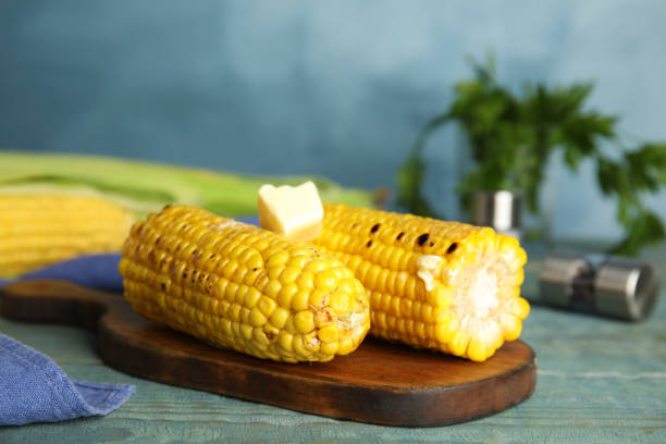 istock Fresh grilled corn cobs with butter on blue wooden table, closeup 1361473009