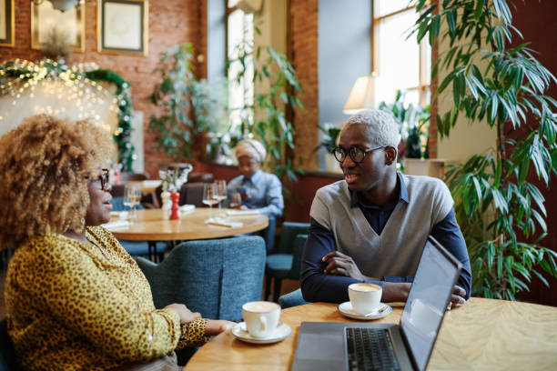 istock Colleagues drinking coffee in coffee shop 1361475012