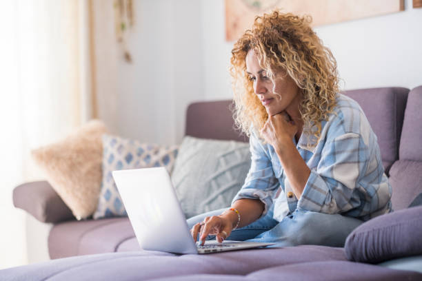 istock Young Woman Using Phone While Sitting On Sofa At Home 1361480751