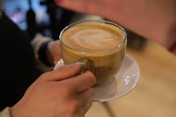 istock woman hands with latte on a wood table 1361484016