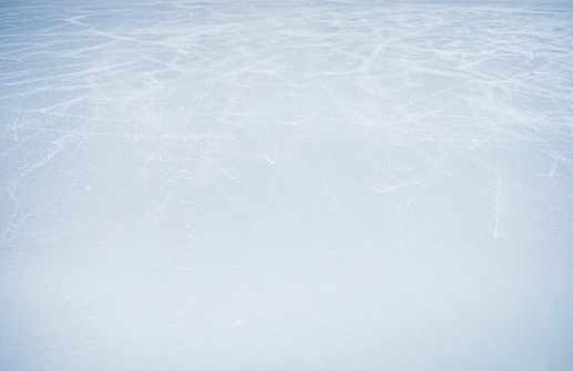abstract light blue ice surface with imprints from figure skates horizontal