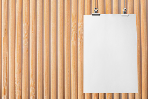 Blank poster hanging near wooden wall. Space for design