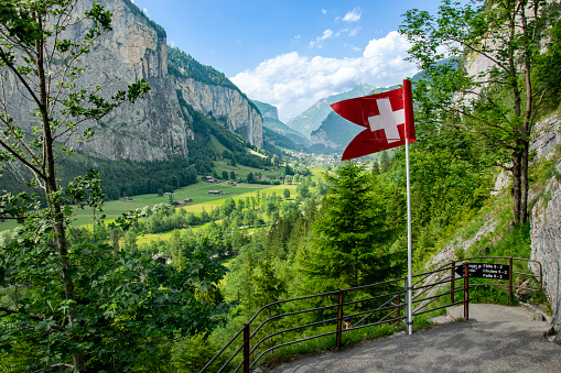 Awesome landscape of Swiss Alps, forest, Swiss flag, hometown of waterfalls