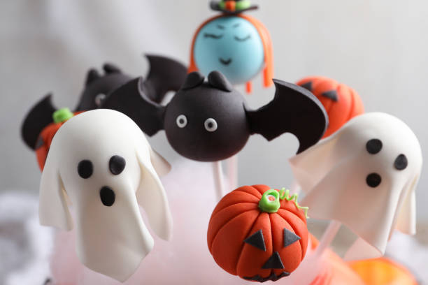 Different Halloween themed cake pops on light background, closeup