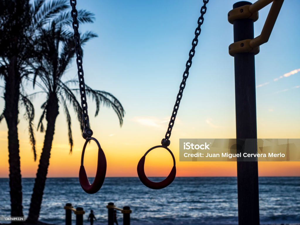 Siluetas frente al mar Silhouettes of gymnastics rings facing the sea at sunset Beach Stock Photo