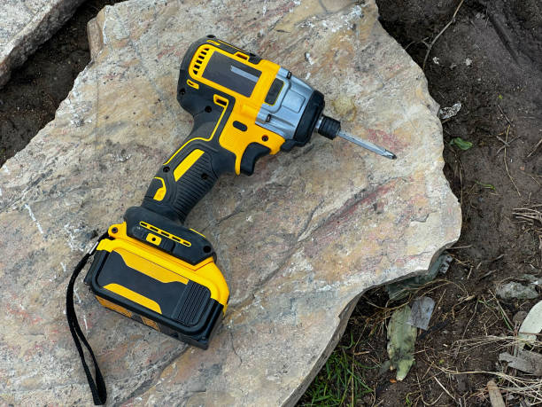 istock cordless screwdriver standing on rock on ground at construction site 1361489859