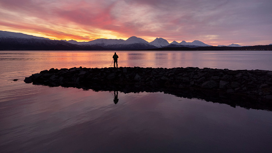 A lonely photographer silhouette in the norhtern Norwegian fjords at sunrise.