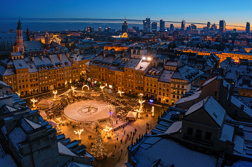 Warsaw, old town market decorated with christmas lights and city center winter aerial panorama at dusk