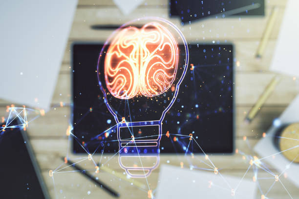 istock Double exposure of creative light bulb hologram with human brain and digital tablet on background, top view, idea and brainstorming concept 1361495260