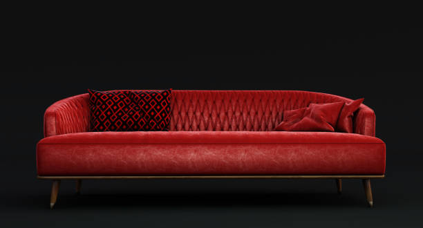 istock Red fabric sofa with pillows isolated on dark background. 1361495566