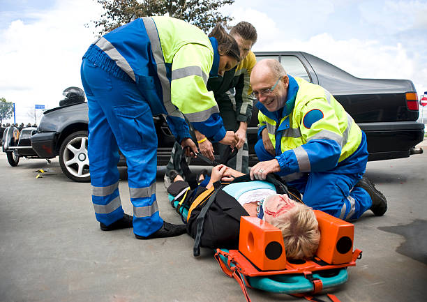 stabilizing firefighter and paramedics stabilize a victim on a stretcher after rescuing her from a car crash sidecar photos stock pictures, royalty-free photos & images
