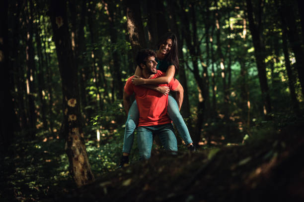 istock Young couple enjoys together walking through the forest. 1361497659