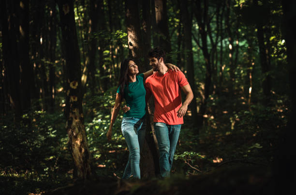 istock Young couple enjoys together walking through the forest. 1361497692