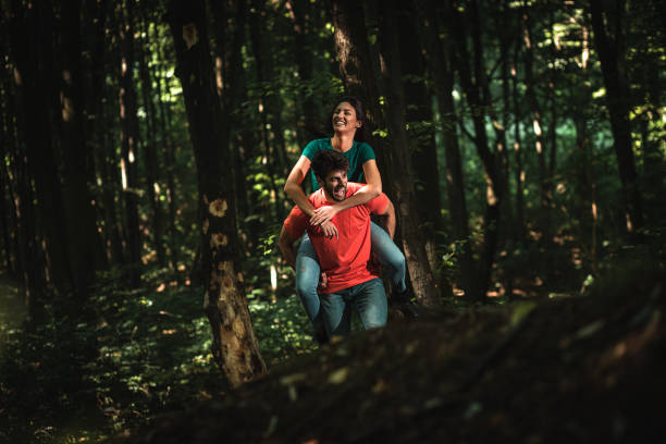 istock Young couple enjoys together walking through the forest. 1361497718