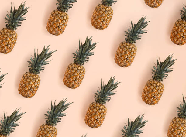 istock Bright pattern of many pineapples on a trendy soft beige pink background 1361497728