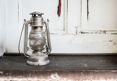 Vintage lantern on rustic wooden doorstep