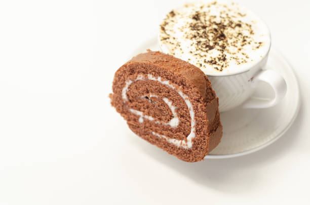 Chocolate sponge roll with a vanilla flavour filling and fresh coffee in the cup, chocolate swiss roll, sweet morning