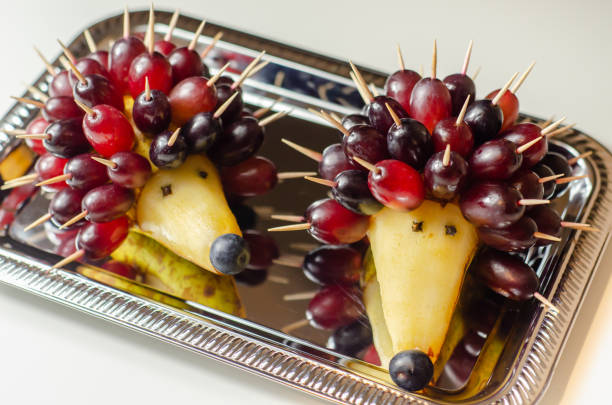 Fruit hedgehog, red grapes and juicy pear, creative way of serving fruit, funny food