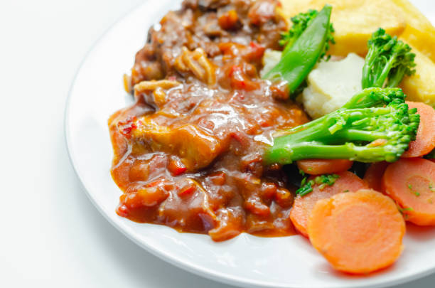 Pulled pork in barbecue style sauce with barbecues style beans with spiced chips and fresh vegetables , american meal