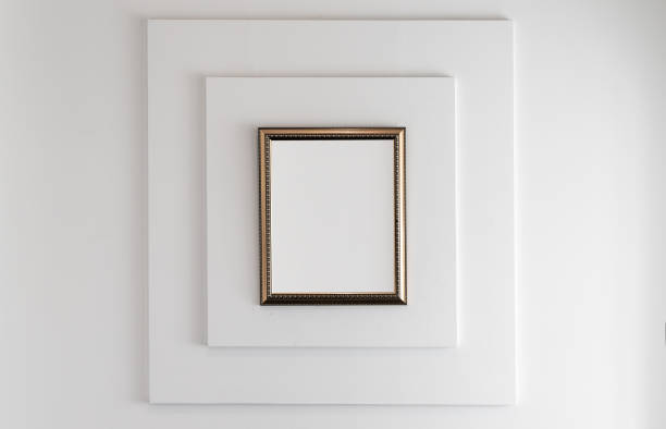 istock Wooden frame with blank white copy space area on a white wall 1361507833