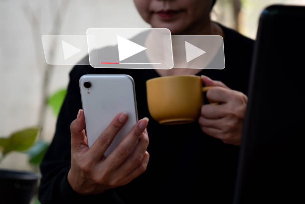 istock A lady is using her mobile phone to stream online, view videos on the internet, or attend a live performance, show, or instruction. Concept of online live streaming video marketing, 1361510780