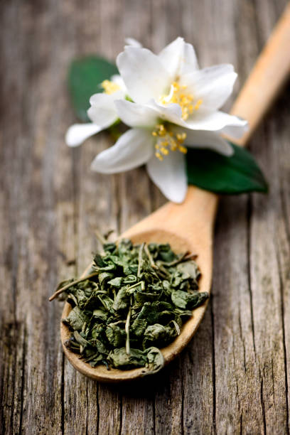 ジャスミンと緑茶の木製スプーン - tea tea leaves jasmine tea leaf ストックフォトと画像