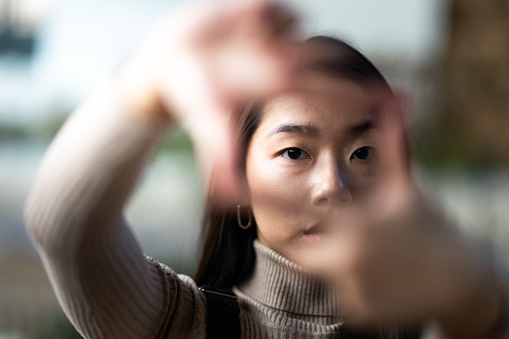 Close up of a young Asian teenage girl framing with her hands
