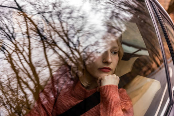 Stressed out woman sitting in the back seat of a cab Stressed out woman sitting in the back seat of a cab car city urban scene commuter stock pictures, royalty-free photos & images