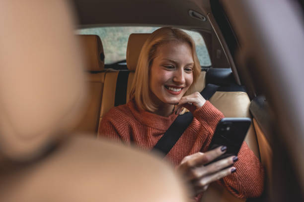 istock Happy woman in car using phone 1361514867