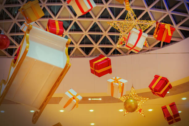 istock Christmas gift boxes sleigh and holiday decorations are suspended from the mall's patterned ceiling. 1361515066