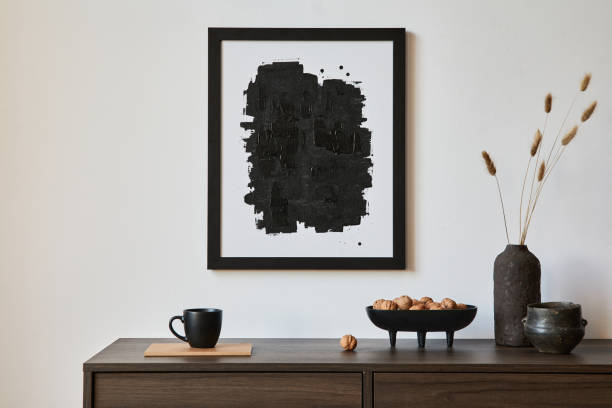istock Minimalistic composition of creative living room interior with mock up poster frame and stylish small personal accessories on wooden commode. Copy space. Template. Real photo.