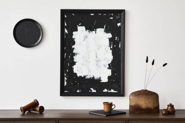 istock Minimalistic composition of creative living room interior with mock up poster frame and stylish small personal accessories on wooden commode. Copy space. Template. Real photo.