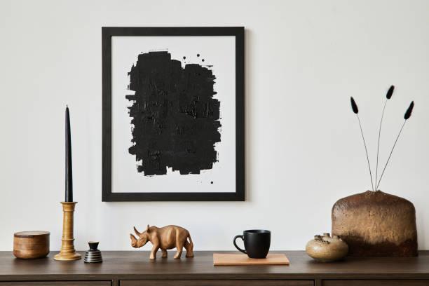istock Stylish living room interior composition with mock up poster frame, brown wooden commode, candlestick and small home decorations. White wall. Copy space. Template. 