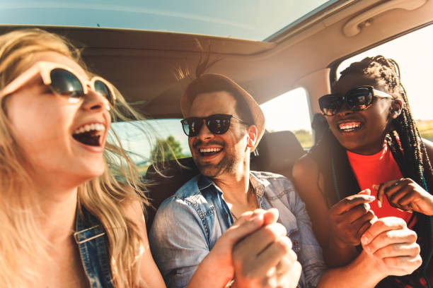 Three best friends enjoying traveling in the car, sitting in rear seat and having lots of fun making selfie on a road trip. Three best friends enjoying traveling in the car, sitting in rear seat and having lots of fun making selfie on a road trip. city break stock pictures, royalty-free photos & images