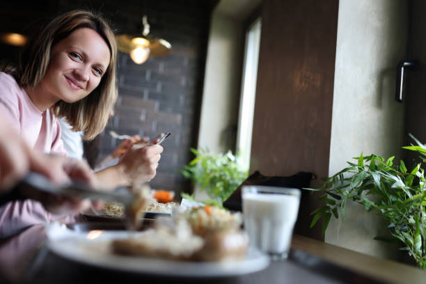 istock Young smiling woman is having lunch in cafe 1361516142