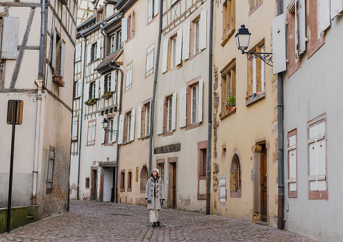 Young Caucasian woman  walking on the streets of Alsace town in France