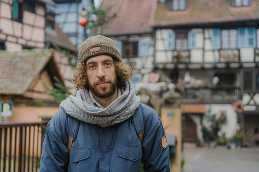 Young Caucasian man  walking on the streets of Alsace town in France