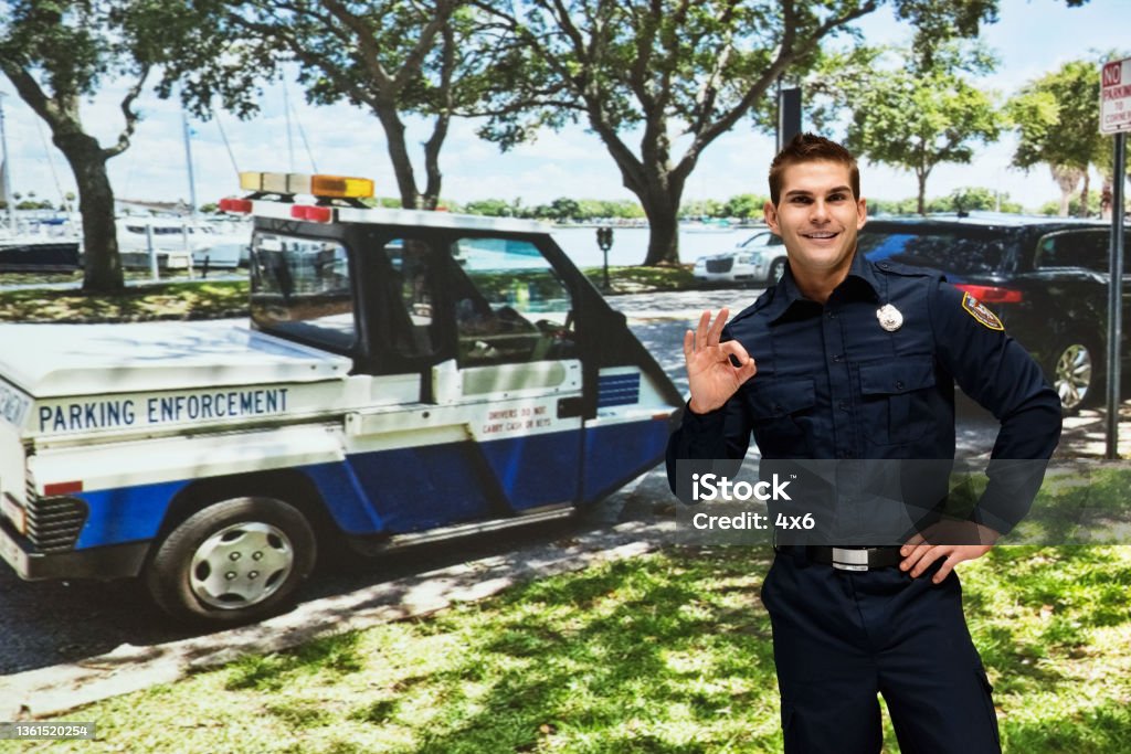 Caucasian male police force wearing hat Front view of aged 20-29 years old with brown hair caucasian male police force wearing hat who is showing cool attitude and showing hand raised Police Force Stock Photo