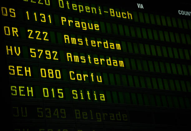 Flight information board at airport terminal closeup.