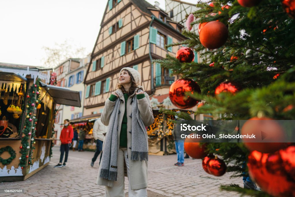 Woman walking near the Christmas tree  in city centre Young Caucasian woman walking near the Christmas tree  in city centre Christmas Stock Photo