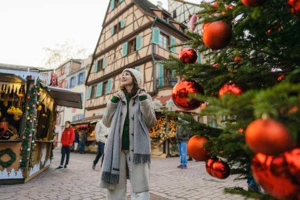 Woman walking near the Christmas tree  in city centre stock photo